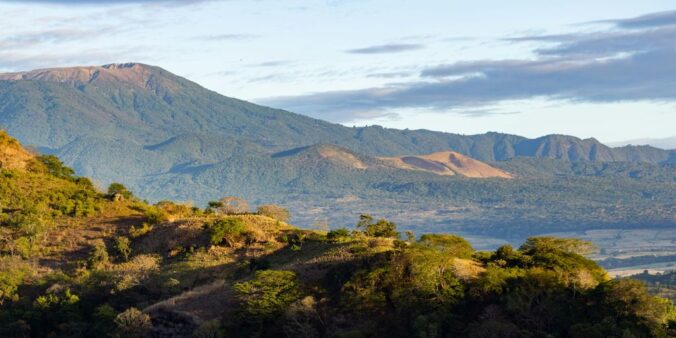 a view of a mountain range with trees and mountains in the background