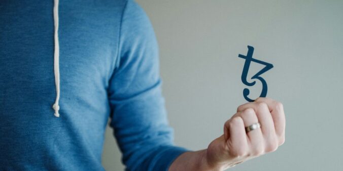 a man in a blue hoodie is holding a piece of paper